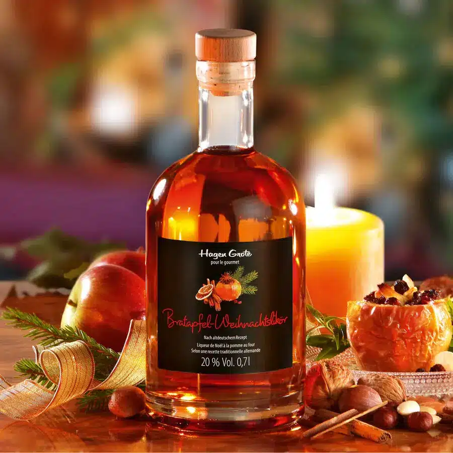 Bratapfel-Weihnachtslik&ouml;r mit Glas, Kerze und winterlicher Dekoration