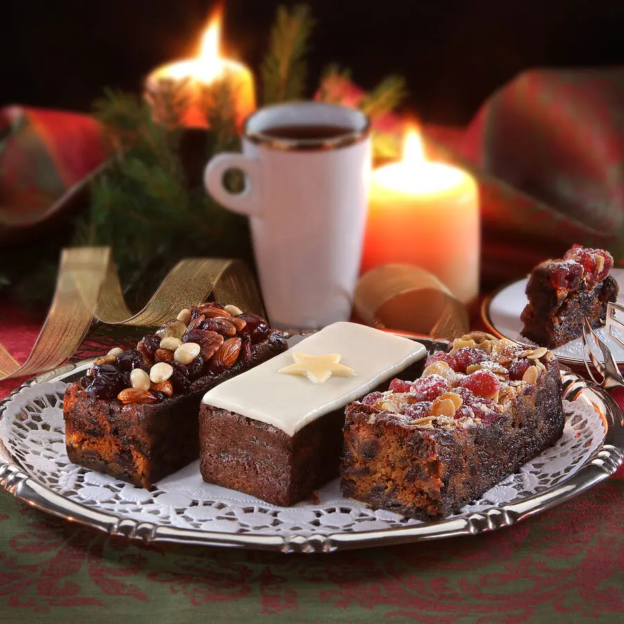 Englands feinste Früchtekuchen mit Mandeln, Kirschen und Rosinen, reich belegt und festlich serviert auf silberner Platte